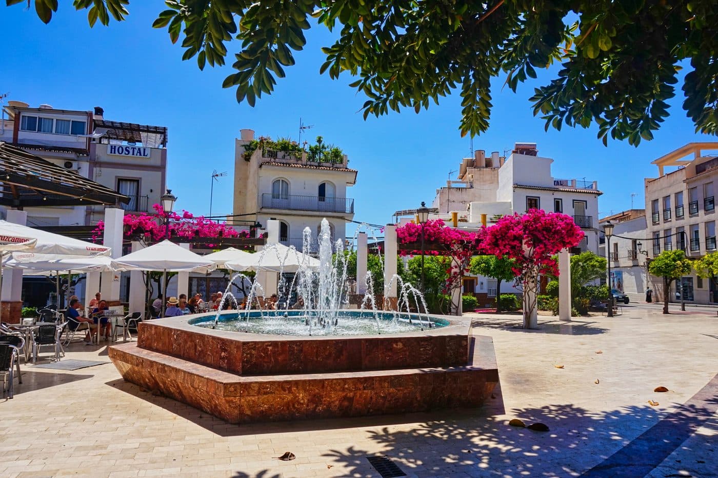 White street in the old centre of Nerja with palm trees towards the Balcón de Europa